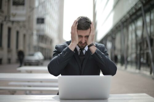 Man in suit looking stressed about his worklife balance
