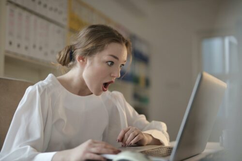 Woman at work in a white blouse looking surprised at R&D tax credit examples