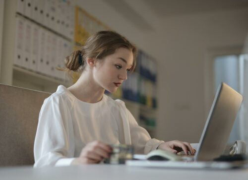 Woman on laptop looking interested about bookkeeping as a service