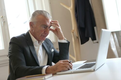 Man in smart suit concentrating on CFO guidance on laptop