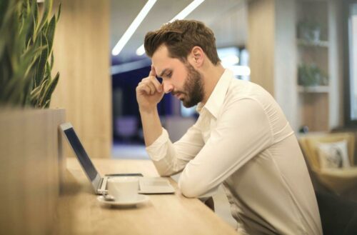 Man looking at laptop worryingly
