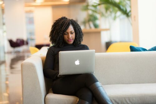 Woman smiling on laptop after achieving a good worklife balance