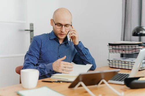 Bald man in polkadot shirt talking on his mobile about unit economics
