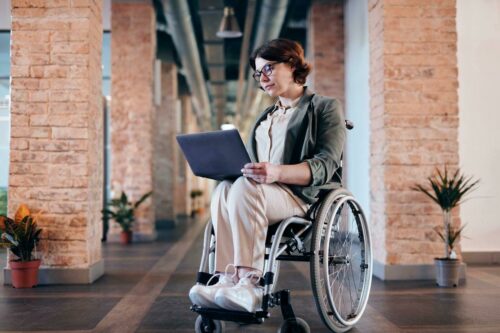 Woman in a wheelchair looking at a laptop