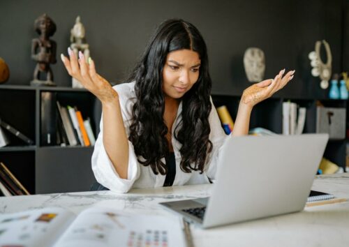 A Woman in White Long Sleeves Using a Laptop