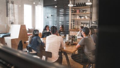 People sitting around a table behind glass